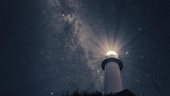Ein Leuchtturm unter einem hellen Sternenhimmel